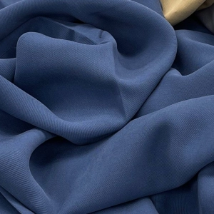 Костюмная ткань синего цвета. Диагональная мелкая выработка, креповая фактура, хорошо струится и держит форму. Идеальна для пошива брюк со стрелкой, косой юбки или жакета.